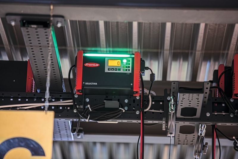 Die Ladegeräte sind beispielsweise an der Wand angebracht – oder in einem Fall sogar über Kopf in die Stahlbaukonstruktion eines Hochregallagers integriert. (Fronius)