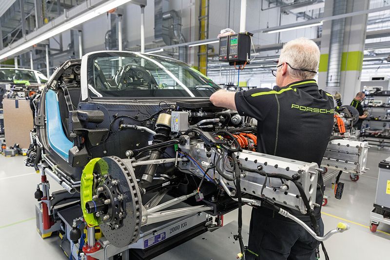 Die akkubetriebenen Hubwagen ermöglichen es dem Werker, das Bauteil hoch- und runterzufahren sowie horizontal und vertikal zu drehen. Eine erhebliche Erleichterung insbesondere beim Verlegen der Kabelstränge. (Bild: Joerg Eberl / Porsche)