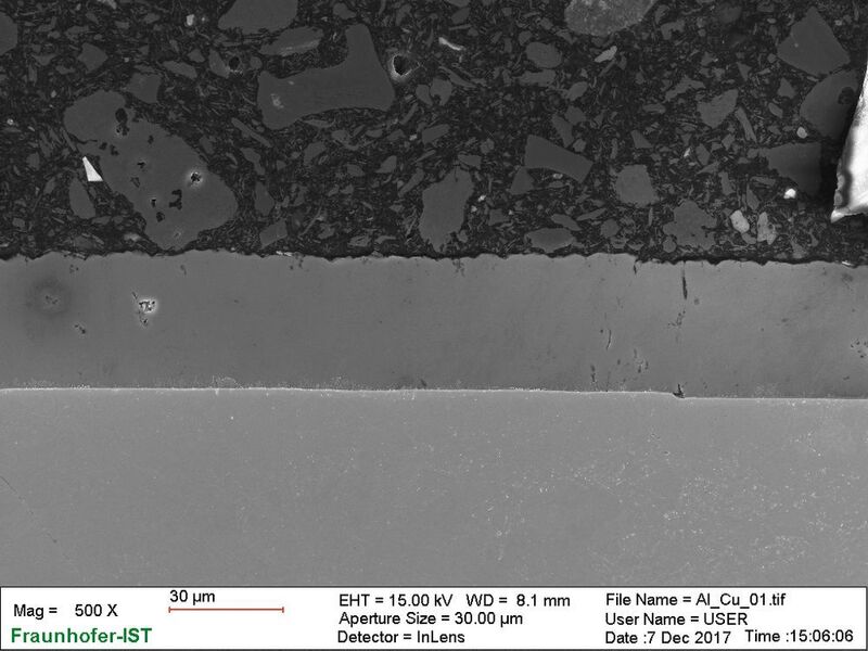 Forscher haben eine Aluminiumabscheidung auf einem Kupfersubstrat realisiert, wie diese REM-Aufnahmen eines Querschliffs zeigen. (Fraunhofer-IST)