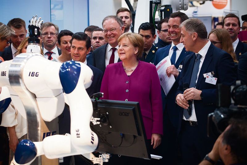 Impressionen vom „Kanzlerinnenrundgang“ am Montag: Dr. Angela Merkel wird am Stand von IGB von einem Roboter begrüßt. (Michael Heck)