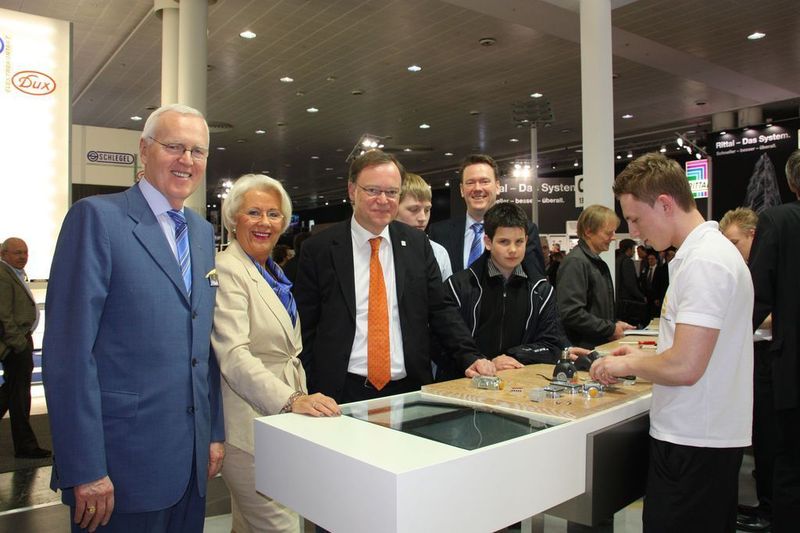 Der Oberbürgermeister der Stadt Hannover, Stephan Weil (3. v. l.), begutachtet zusammen mit Dietmar und Margrit Harting den neuen Steckverbinder. (Im Hintergrund: Philip Harting). (Archiv: Vogel Business Media)