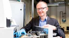 Stephan Reitzenstein vor der Probenkammer der Elektronenstrahl-Lithographie-Anlage: Diese Anlage stellt die hochpräzise Nanostrukturen für skalierbare Quantenlichtquellen her. (Bild: Felix Noak)