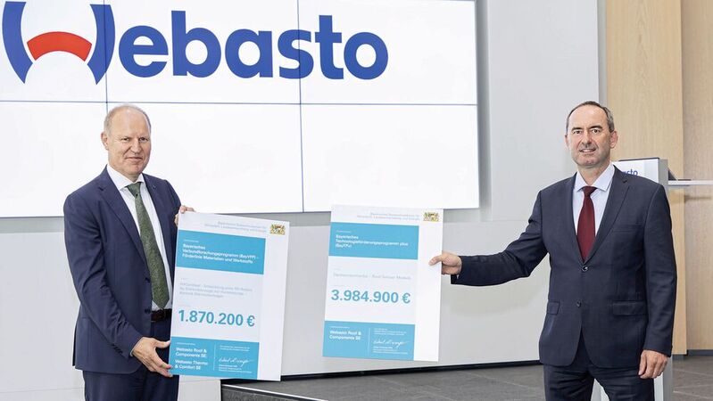 Bayerns Wirtschaftsminister Hubert Aiwanger (rechts) überreicht Webasto-CEO Holger Engelmann die Förderurkunden.