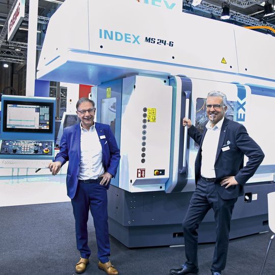 Philippe Dubois (li.) und Rainer Gondek (Marketingleiter) vor dem Mehrspindeldrehautomaten Index MS24-6, bei dem das Tausendstel am Werkstück «ankommt».(Bild:  Matthias Böhm)