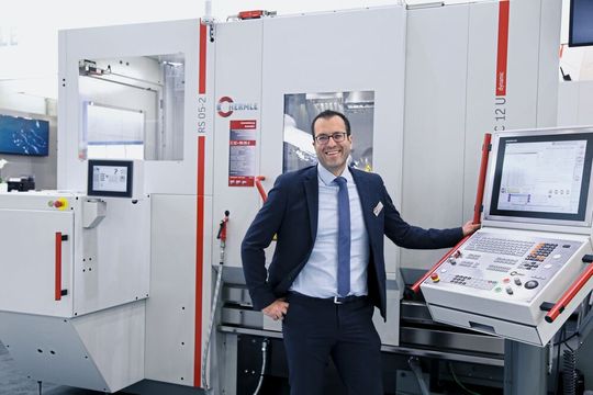 Gerd Messmer vor der Hermle C12U mit integrierter RS05-2-Automation. Eine Werkzeugmaschine, die perfekt zugeschnitten ist für die mannlose Fertigung. (Bild:  Matthias Böhm)