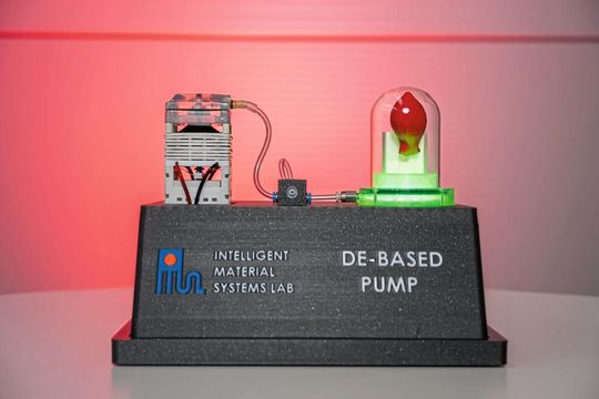 Um die Technologie für die Messebesucherinnen und -besucher anschaulich zu machen, haben die Forscher diesen Demonstrator gebaut: Die smarte Folie zieht hier ein Vakuum in einer Vakuumglocke. Sichtbar wird dies an dem roten Luftballon, der sich im Innern der Glasglocke selbst „aufbläst“ – eine Anordnung wie im Physikunterricht: Da die Luft um den Ballon herum abgesaugt wird, haben die Luftteilchen im Ballon mehr Platz, sich auszudehnen – nur, dass dies hier ganz ohne die laute Geräuschkulisse des Druckluftkompressors von statten geht.(Bild:  Oliver Dietze)