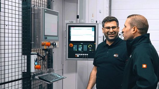 Benjamin Klenk et Marcel Sütterlin devant l'ordinateur central qui donne en un coup d'œil toutes les données sur l'état de la machine, les outils, les dispositifs de serrage, les périphériques, les composants d'automatisation, et la productivité.(Source :  Helfina AG)