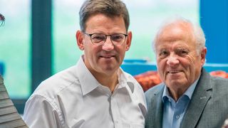 Die modernen Torquemotoren von Johannes (l.) und Bernhard Oswald – hier schauen sie durch einen gewickelten Stator – verringern den Energieverbrauch um bis zu 50 %, der Einsatz von Getriebeöl fällt weg und die Maschinen werden leichter. Dafür hat sie der DBU geehrt.  (© Jens Kortus Fotografie Miltenberg)