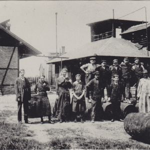 The facilities in Rheinau in an early photograph taken around 1910: behind the staff and to the right you can see the wooden, open-air production hall.