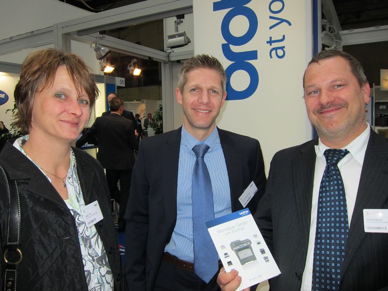 Stefan Heizmann, Brother (m.), empfiehlt Heike Treitl und Harald Meyer, BuD IT, seine Monolaser-Geräte. (IT-BUSINESS)