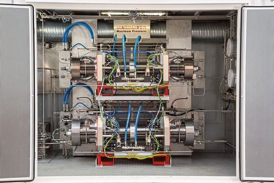 H2-Container: Der patentierte Max Compression ist ein 2-stufig aufgebauter, fluidisch (HFC) angetriebener Kolbenhochdruckverdichter, der Wasserstoff von 24 bar auf max. 1.000 bar verdichtet. H2-Container: Der patentierte Max Compression ist ein 2-stufig aufgebauter, fluidisch (HFC) angetriebener Kolbenhochdruckverdichter, der Wasserstoff von 24 bar auf max. 1.000 bar verdichtet.