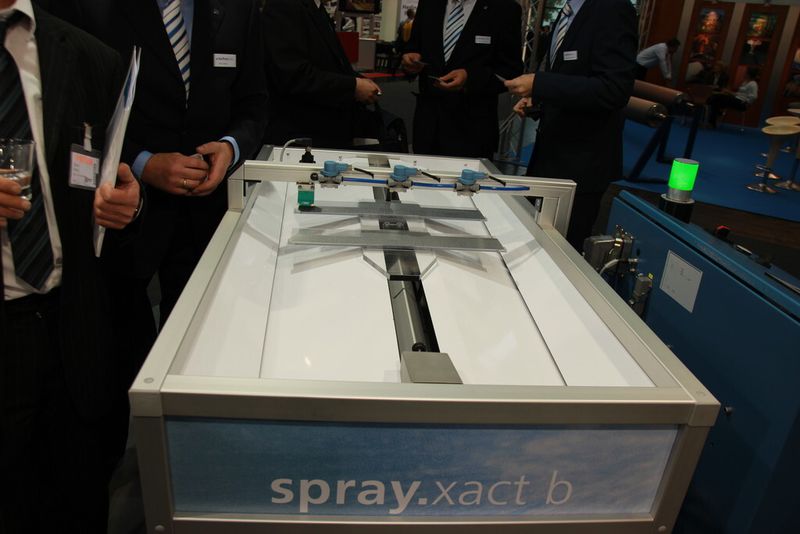 Bild 5: Mit einem Demonstrator, dessen Düsen mit Wasser arbeiteten, zeigte die Technotrans AG auf der Euroblech 2012, wie fein sich die zu applizierende Ölmenge einstellen lässt. Da die Anlage über den besagten Sensor verfügt, der die Bandgeschwindigkeit erkennt, sorgt sie für eine immer exakt gleiche Auftragsmenge, egal wie schnell die Werkstücke vorbeigleiten. (Bild: Königsreuther)