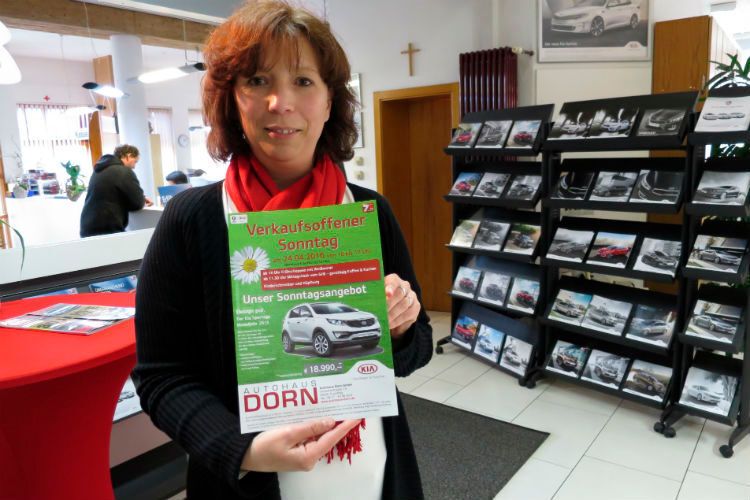 Die nächste Veranstaltung im Autohaus ist schon geplant. Monika Dorn zeigt das Plakat für das Frühlingsfest. (Foto: Lulei)
