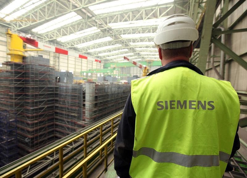 Mitarbeiter vor der Offshore-Plattform Helwin1 auf der Werft. (Bild: Siemens)