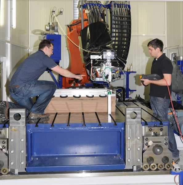 Mitarbeiter des Instituts für Leichtbau und Kunststofftechnik (ILK) an der PUR-Sprühanlage. (Bild: Geller)