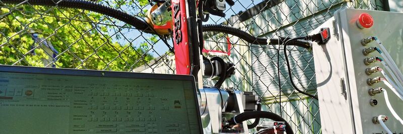 Versuchsaufbau: Der Roboter wird per Laptop bewegt und kann so beispielsweise ein Rütteln am Zaun imitieren, das die Sensoren im Kabel registrieren.