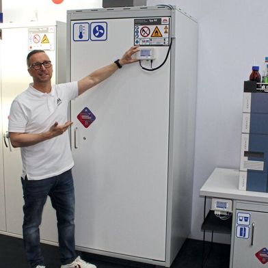 Christian Völk, Marketingleiter bei DÜPERTHAL, zeigt das Panel am Sicherheitsschrank, das mithilfe der integrierten Sensorik ständig über den Funktionszustand des Schranks informiert. (Bild: VCG – Platthaus)