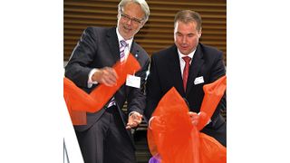 Mit dem symbolischen Durchtrennen eines Bandes eröffnen Horst Schneider, Oberbürgermeister der Stadt Offenbach (l.), und Uwe Geissinger, CEO Dematic Central Europe, das neue Tech-Center am Standort Offenbach. Bild: Maienschein (Archiv: Vogel Business Media)