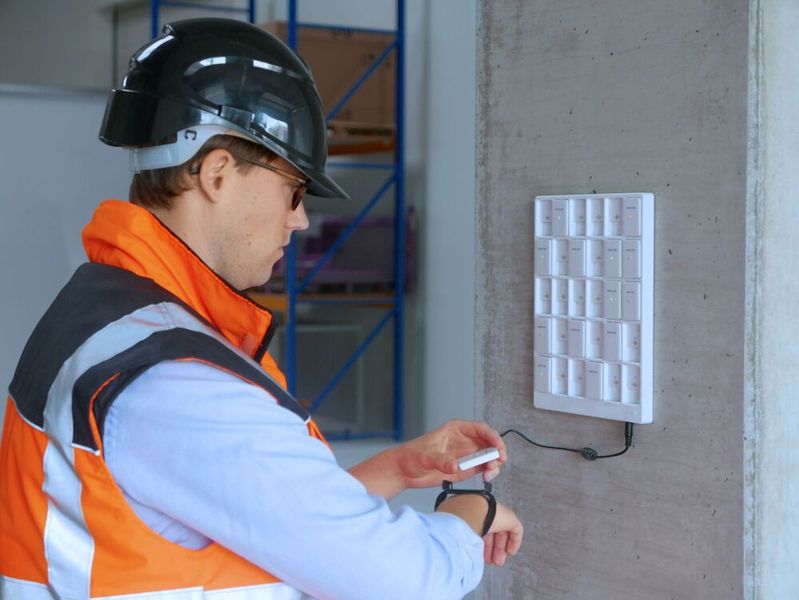 Zum Arbeitsbeginn nimmt der Mitarbeiter den Kinexon SafeTag aus der Ladeschale. (Bild: Kinexon)