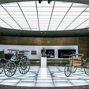 Mercedes-Benz Museum, Stuttgart. Benz Patent-Motorwagen (rechts) und Daimler Motorkutsche (links) im Raum Mythos 1: Pioniere – Die Erfindung des Automobils, 1886 bis 1900. In der Mitte die Daimler „Standuhr“ – der erste kleine, schnelllaufende Verbrennungsmotor. (Bild: Mercedes-Benz AG)