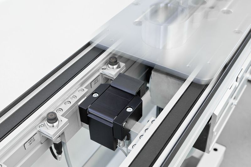 Die mittig angeordneten Stopper mit integrierter Dämpfung verhindern ein Verkanten der Werkstückträger in den Führungsleisten. Sensoren ermöglichen dabei die Erkennung eines Carriers auf dem Band und somit das Auslösen der Stopper. (Bild: IEF Werner)