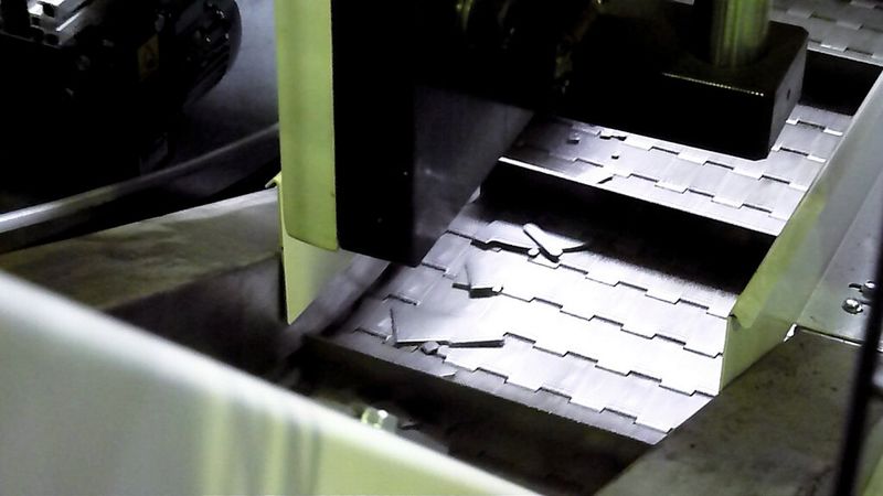 Die Stanzabfälle fallen unterhalb des Werkzeuges heraus, werden zurück- und dann seitlich über ein Förderband hochtransportiert ... (Bild: Kuhn)