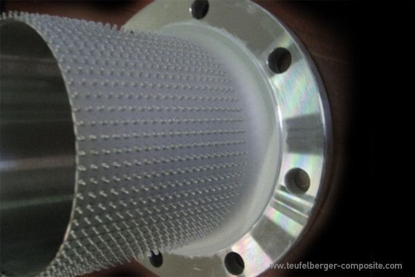 Entsprechend der Lastverteilung im Bauteil bringt Teufelberger beim T-Igel eine regelmäßige Pinstruktur auf einen metallischen Grundkörper auf, welche im Haus in eine Flechtstruktur integriert und zu einem hybriden Composite Bauteil konsolidiert wird. (Bild: Teufelberger)