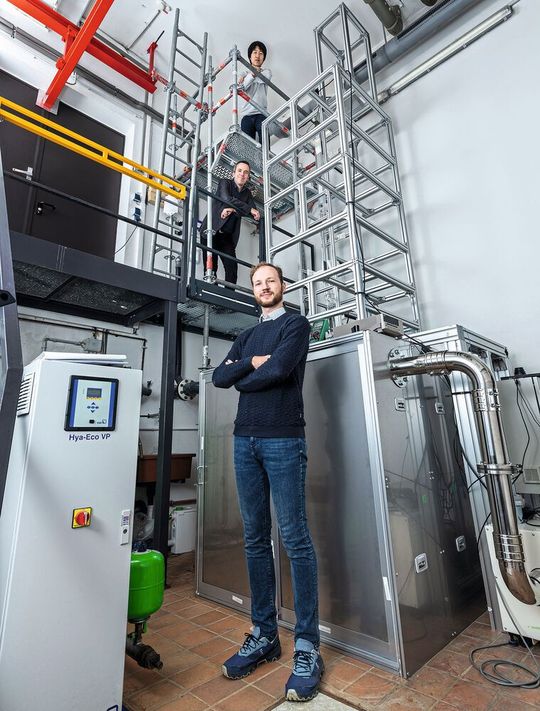 Von unten nach oben: Dr. Simon Jantac und Dr. Holger Großhans sind die Autoren der Studie. Ganz oben steht Dr. Wenchao Xu, der die mehrere Meter hohe Apparatur zur Untersuchung der elektrostatischen Aufladung von Staub konstruiert hat und betreut.(Bild:  Physikalisch-Technische Bundesanstalt)