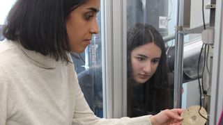 Ist der Werkstoff Vulkanfiber für Gehäuse zukünftiger Batteriegenerationen geeignet? Im Labor untersuchen die wissenschaftlichen Mitarbeiterinnen Kardelen Bayram (vorne) und Lea Aydin dessen Crashtauglichkeit. (Technische Hochschule Mittelhessen)