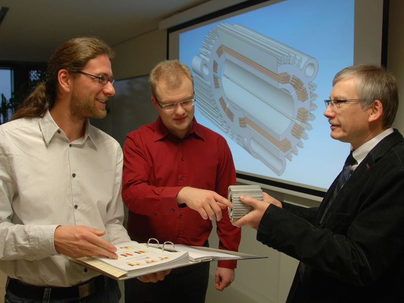 Mathias Lindner, Patrick Bräuer und Prof. Dr. Ralf Werner (v.l.) von der Professur Elektrische Energiewandlungssysteme und Antriebe diskutieren, wie sich die Kennwerte bei einem Stator eines elektrischen Antriebsmotors voraussichtlich verbessern, der künftig mittels Siebdruck gefertigt werden soll. (TU Chemnitz/Mario Steinebach)