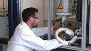 Doktorand Elias Frei kontrolliert die Temperatur im Reaktor des Katalysator-Teststands. (Bild: FMF)