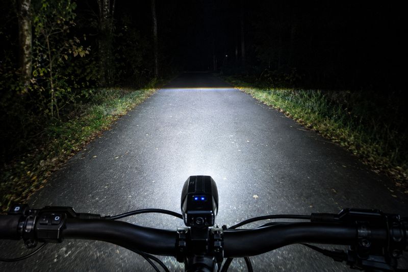 Ein optimal eingestellter Scheinwerfer leuchtet die Fahrbahn aus, hat aber eine scharfe Kante nach oben. Auf unbeleuchteten Strecken sind 100 Lux oder sogar das seit 2017 erlaubte Fernlicht sinnvoll. (Bild: KI-generiert / Dall-E)