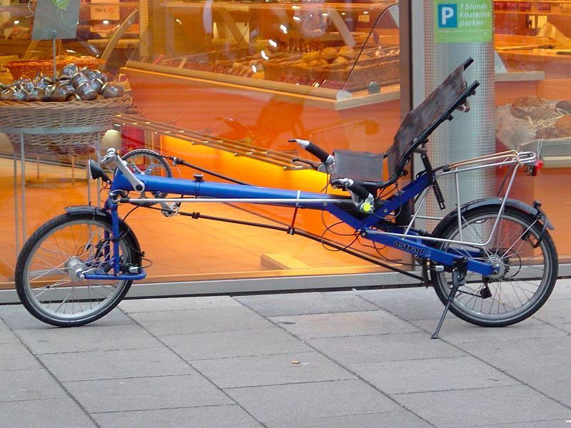 Liegeräder (im Bild ein modernes Modell) existieren bereits länger: Schon 1914 bot Peugeot serienmäßig eine solche Fahrradvariante an, bei denen der Fahrer näher am Boden und am Hinterrad sitzt und das Rad quasi liegend steuert und antreibt. Aufgrund des niedrigeren Schwerpunkts und der geringeren Sturzhöhe gelten Liegeräder bei Enthusiasten als sicherer, dennoch führt dieser Fahrradtypus bis heute eher ein Schattendasein. (Reise Reise / Wikimedia Commons)