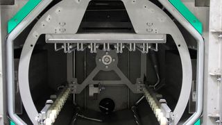 Mit einem speziellem Niederhalter in der Korbaufnahme werden die unterschiedliche Werkstückträger ohne Rüstaufwand fixiert. (BVL Oberflächentechnik)