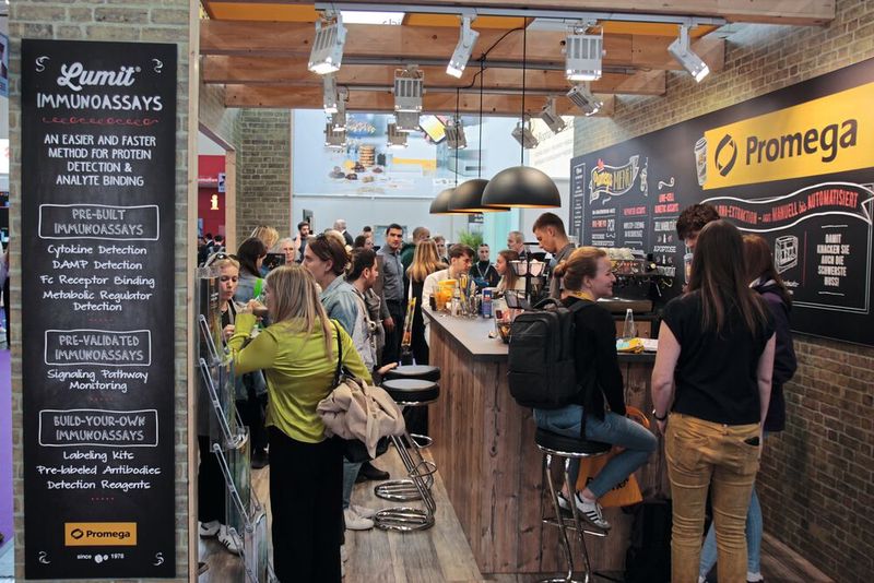 Besonders kreativ war das Stand-Design von Promega im Stil einer Bar. Auf der Cocktailkarte: Immunoassays und Lösungen zur RNA-Extraktion (Kaffee gab es aber auch). (Bild: VCG – C. Lüttmann)