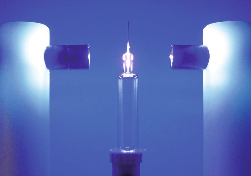 Eine Metallnadel wird in eine Glasspritze verklebt: Der Klebstoff wird mit zwei LED-Köpfen ausgehärtet. (Bild: Panacol)
