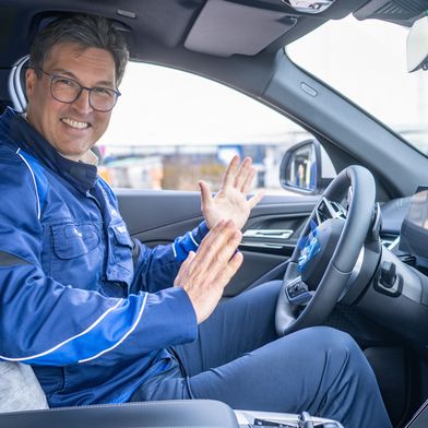Armin Ebner, Leiter des BMW-Werks Regensburg in einem automatisiert fahrenden Neufahrzeug. (Bild: BMW)