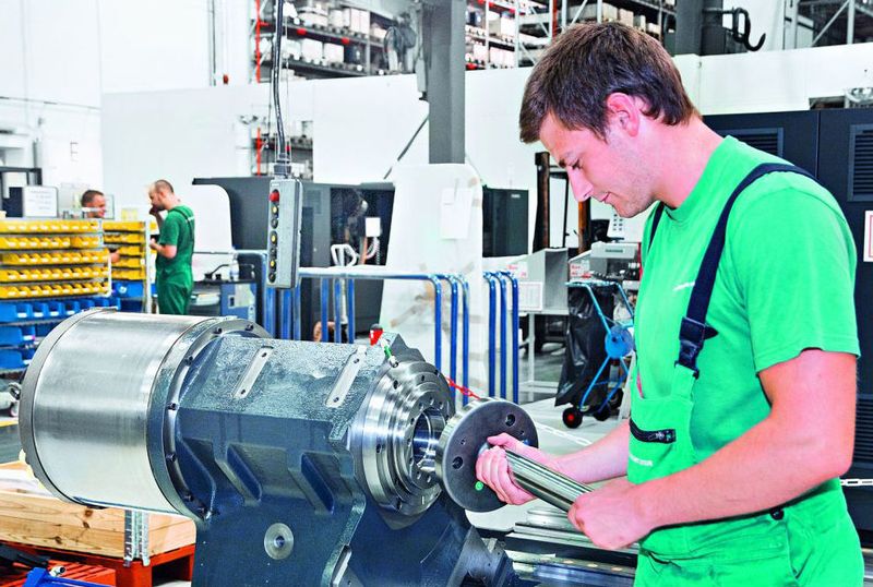 Michael Hannig, Auszubildender bei der Gildemeister Drehmaschinen GmbH, fügt ein Maschinenteil in die Universal-Drehmaschine CTX Beta ein. Bilder: Gildemeister (Archiv: Vogel Business Media)