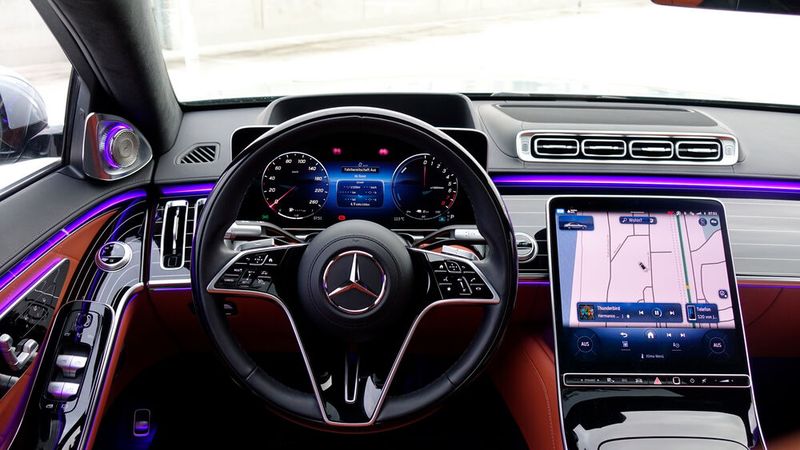 17. Das Cockpit: Wer das Pech hat, nicht hinten rechts zu sitzen, sondern die S-Klasse fahren zu müssen, kommt auch voll auf seine Kosten. Der Fahrer bekommt im Prinzip die gleichen Komfortfunktionen wie der Gefahrene. Den Sitz kann er dank insgesamt 19 (!) Stellmotoren individuell an seine Rückenform anpassen – sei sie auch noch so mekrwürdig. Nicht über jeden Zweifel erhaben ist die Bedienung der Tasten am Lenkrad – das klappt nicht immer wirklich gut. Und auch durch die Gestensteuerung kommt es dann zu durchaus lustigen Situationen, zum Beispiel, wenn man unbewusst gestikuliert und sich bei Regen plötzlich das Dach öffnet.  (Bild: Schreiner – VCG)