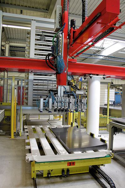 Fahrwagen aus der Längsstation II in der Übergabeposition unter dem mit einer Vakuum-Saugeinrichtung bestückten Portalroboter: Der Fahrwagen ist zur sicheren Vereinzelung der Bleche ab Palettenstapel mit einem Spreizmagneten ausgerüstet. (Bild: Kasto)