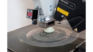 In Stade wurde auch eine per Roboter geführte Vakuumsaugstrahl-Düse für die saubere Oberflächenvorbehandlung von Composite-Teilen entwickelt. Hier sieht man sie beim sogenannten Schäften und Aktivieren eines mit Carbonfasern verstärkten Kunststoffteils (CFK). (Bild: Fraunhofer IFAM)