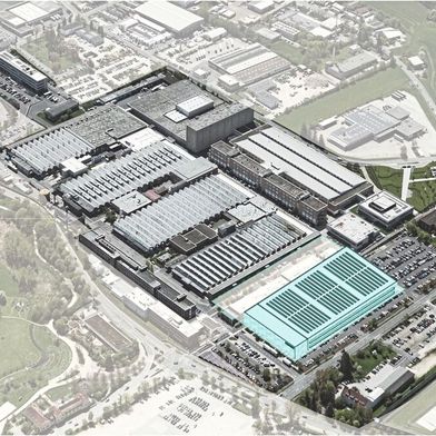 Das Bild zeigt eine Luftbildaufnahme des bestehenden Standorts, ergänzt um eine Visualisierung der Smart Factory. Auf dem heutigen Parkplatz soll die neue Fertigung entstehen.   (Bild: Siemens AG)