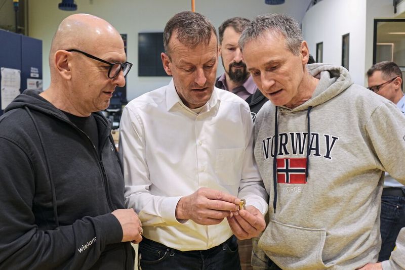 Wieland process engineer Angelos Tanios (left), Iscar application technician Martin Staudacher (center), and Thomas Eiberle, machine operator at Wieland, examine the model. (Image:Iscar)