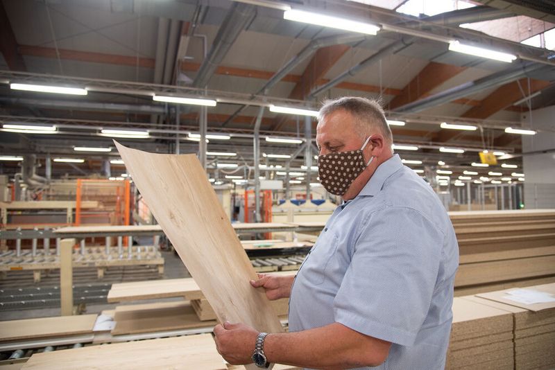 Franz Nitsche informiert über die Echtholzfurniere, die hobb Holzveredelung für seine Produkte verwendet. (FH Münster / K. Kipp)