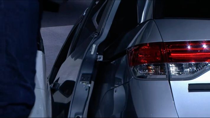 Wenn man am rechten Minivan mal die Türe öffnet, sieht man, dass sie nur einen schmalen Spalt aufgeht, der zu klein ist, um  durch zu kommen.  (Tesla)