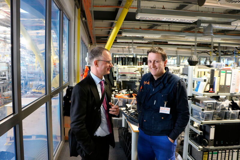 Durch eine dicke Glaswand getrennt sind Produktion und Testlabor (links) von den Ingenieursarbeitsplätzen. Betriebsleiter Igor Iraeta (r) erklärt Chefredakteur Frank Jablonski die Abläufe.  (Jablonski)