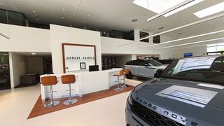 Das Nürnberger Autohaus Feser Scharf hat die jüngste JLR-CI umgesetzt. Zu den Showroom-Elementen zählt eine neue Empfangstheke. Sie wurde vom Eingangsbereich nach hinten gerückt. (Bild: Mauritz – VCG)