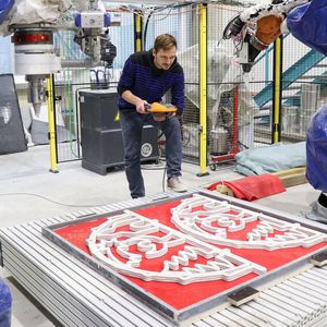 Enrico Rudolph vom Forschungsbereich "Leichtbau im Bauwesen" untersucht nach der Fertigung der Schwibbögen die Qualität des Schichtaufbaus des 3D-Betondrucks.(Bild:  Susanne Viertel)