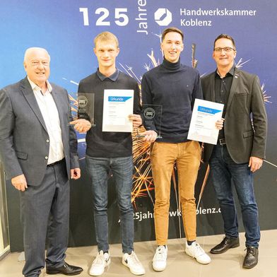 Die beiden neuen Deutschen Meister Hannes Wirsing (Kfz-Mechatroniker, 2. v. li.) und Mark Guttek (Automobilkaufmann). Sie wurden beglückwünscht von Hans Werner Norren (li.), Präsident des Landesverbandes Rheinland-Pfalz und Joachim Noll, Arbeitnehmer-Vizepräsident der Handwerkskammer Koblenz.  (Bild: Schmidt - VCG)