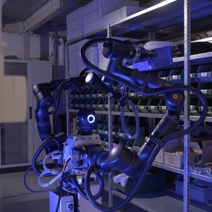 ier greift der humanoide Roboter von Bosch Rexroth das entsprechende entsprechendes Bauteil im Regal.(Bild:  Bosch Rexroth AG)